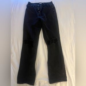 Dad jeans, ripped at knees.